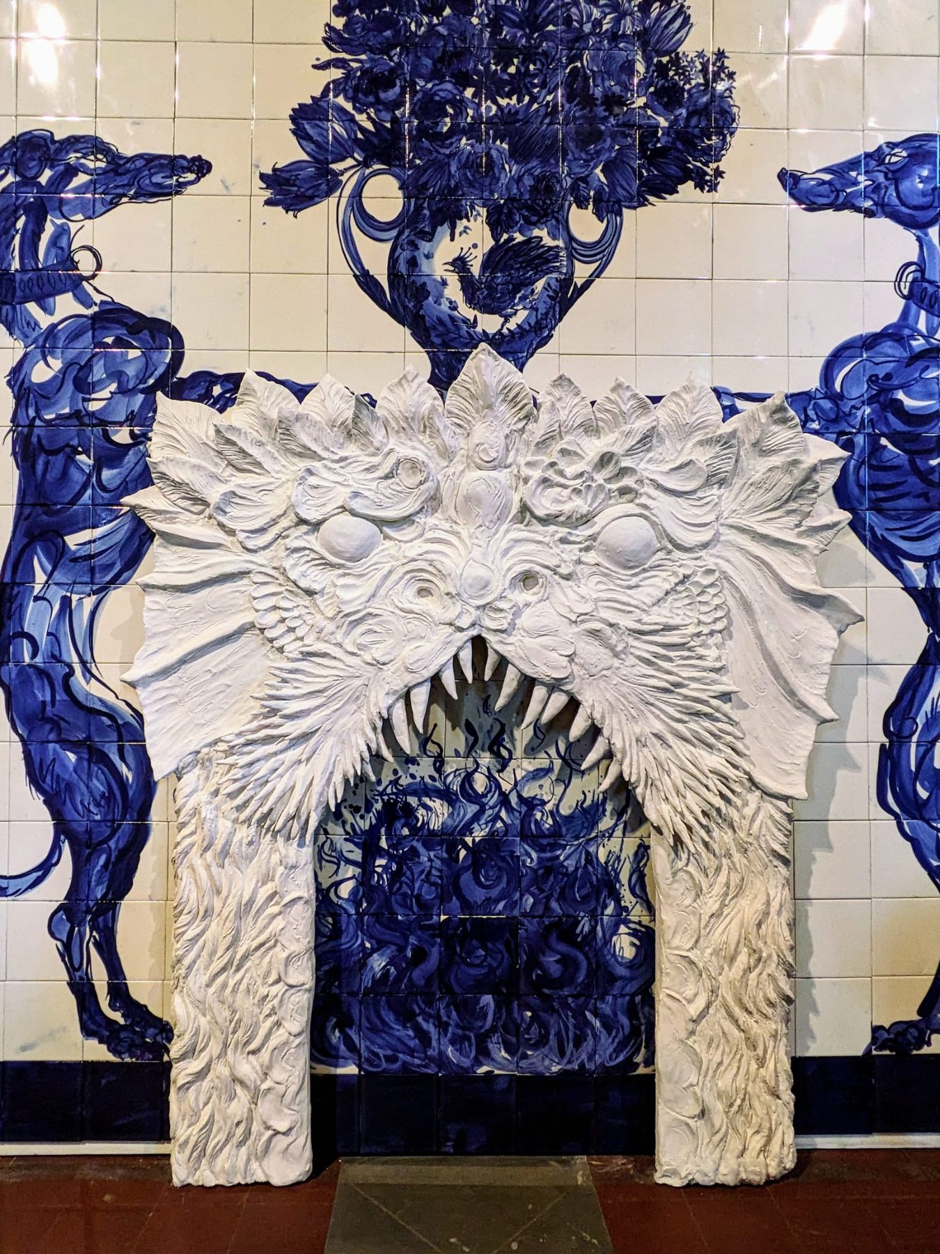 There Are Devils in My House — detail of the sculptural archway against the blue-and-white mural